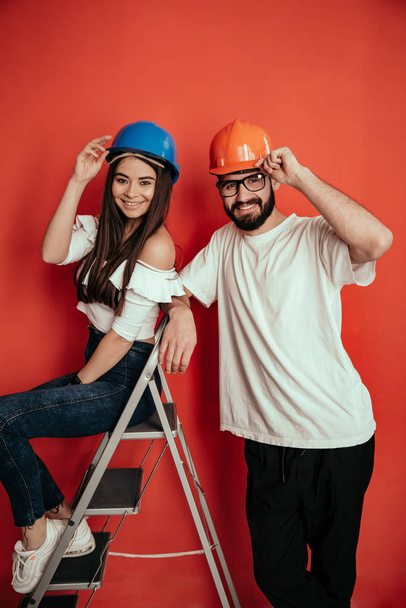 Jovens construtores femininos e masculinos entusiasmados se alegram com o acabamento bem-sucedido da construção, têm grande sucesso e triunfo
 - Foto, Imagem