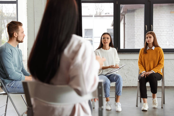 Psychotherapist working with patients in group therapy session indoors - 写真・画像