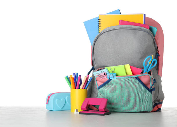 Bright backpack with school stationery on grey stone table again - Фото, зображення