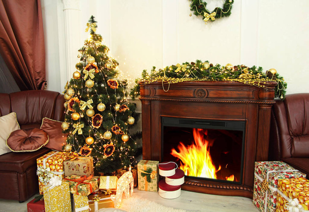 Christmas fir-tree, christmas decorations and gifts near firepla - Foto, imagen