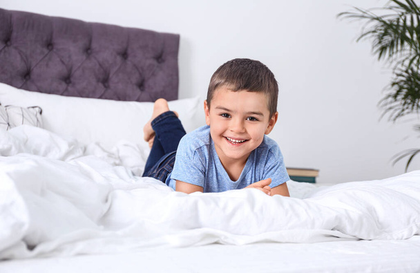 Cute little boy lying on bed at home - Photo, Image