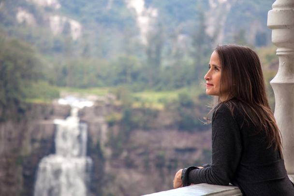Vrouwelijke toerist bezoekt de beroemde Tequendama Falls ten zuidwesten van Bogota in de gemeente Soacha  - Foto, afbeelding