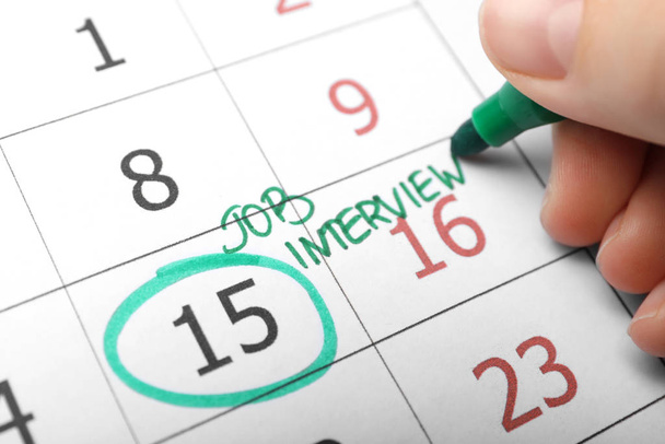 Woman marking date of job interview in calendar, closeup - Foto, Bild