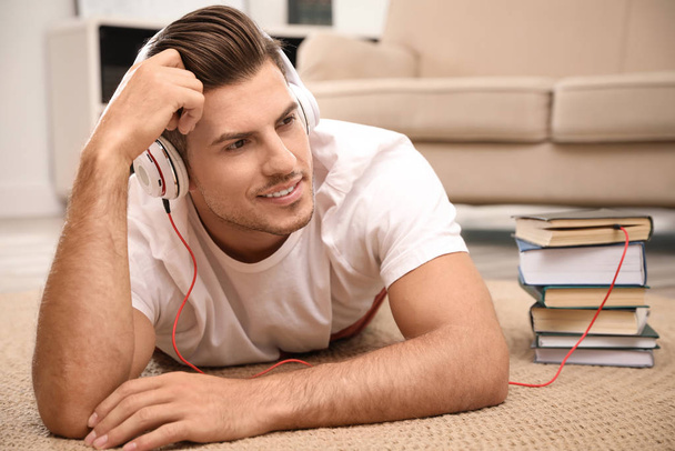 Man with headphones connected to book - Φωτογραφία, εικόνα