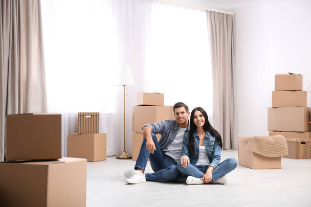 Счастливая пара в номере с картонными коробками в день переезда
 - Фото, изображение