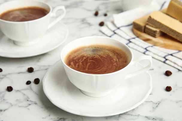 Delicioso café y obleas para el desayuno en la mesa de mármol blanco
 - Foto, imagen
