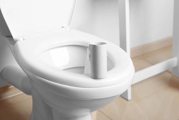 Empty paper roll on toilet seat in bathroom - Φωτογραφία, εικόνα