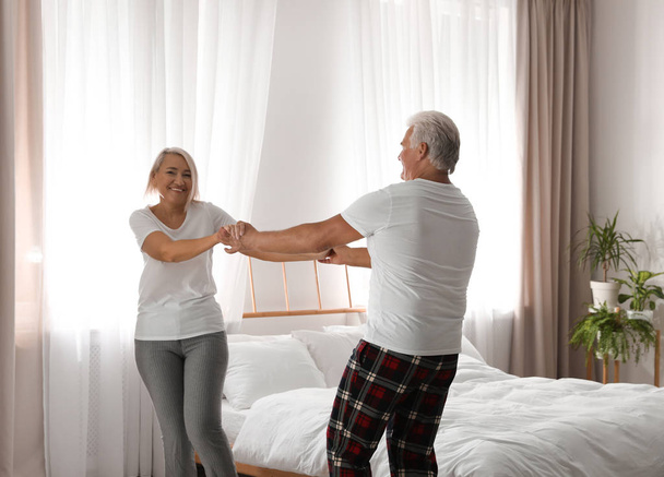 Happy mature couple dancing together in bedroom - Zdjęcie, obraz