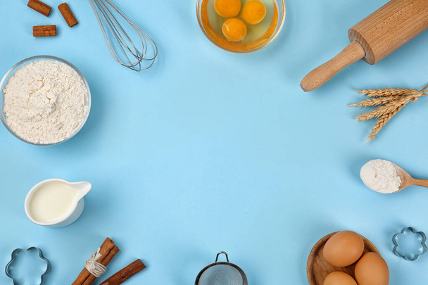 Flat lay composition with raw eggs and other ingredients on light blue background, space for text. Baking pie - Photo, Image