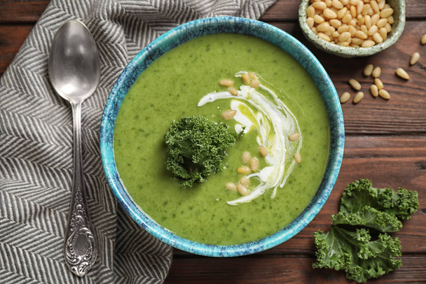 Tasty kale soup served on wooden table, flat lay - Photo, image