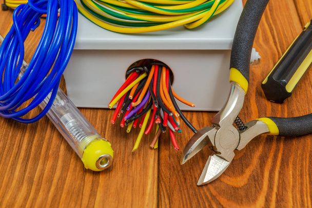 Skrzynka przyłączeniowa z kablami i narzędziami stosowanymi w procesie instalacji elektrycznej - Zdjęcie, obraz