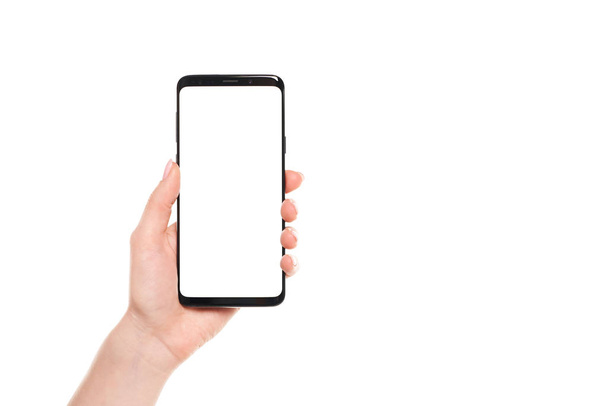 Női kéz tartja a fekete okostelefon üres képernyő modern keret nélküli design elszigetelt fehér háttér - Fotó, kép