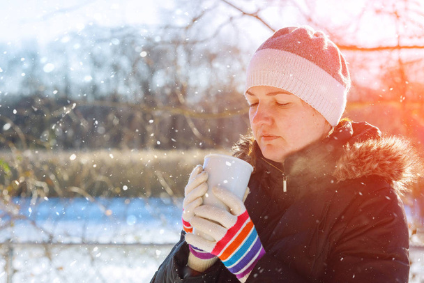 Mujer bebiendo té caliente al aire libre en invierno día soleado
 - Foto, Imagen