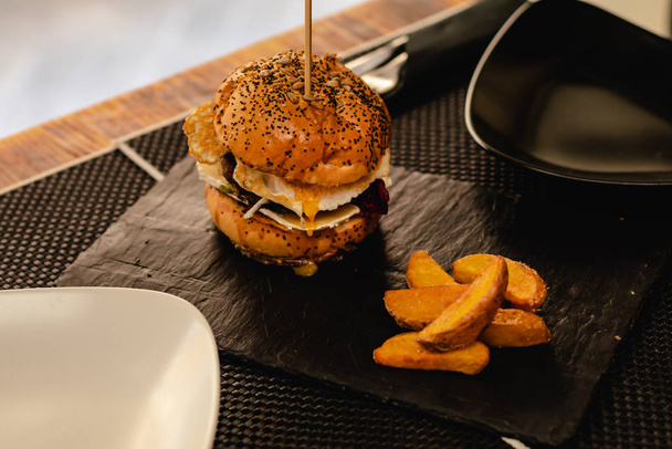 Burger with egg and fries served on restaurant - Φωτογραφία, εικόνα