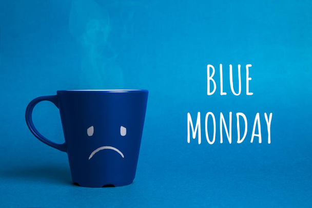 Foto stock de uma xícara segunda-feira azul em um fundo azul
 - Foto, Imagem