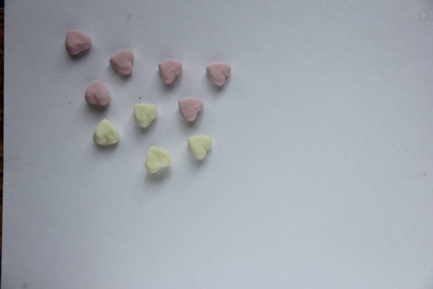 marshmallow pink and yellow in the form of a heart lies on the surface - Photo, image