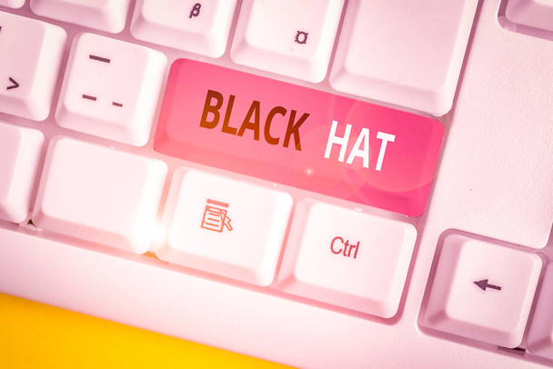 Conceptual hand writing showing Black Hat. Business photo text used in reference bad demonstrating especially a villain or criminal White pc keyboard with note paper above the white background. - Photo, Image