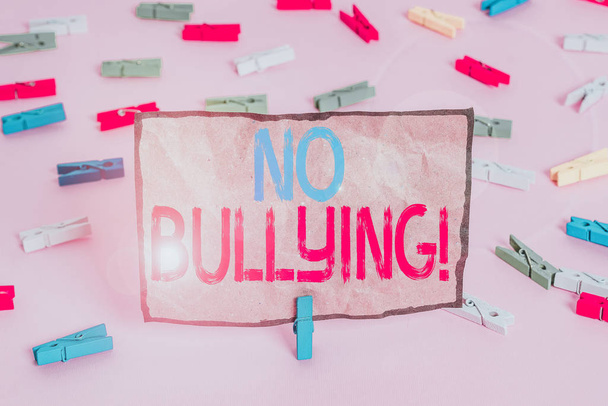 Χειρόγραφο κείμενο που γράφει No Bullying. Έννοια σημαίνει στάση επιθετική συμπεριφορά μεταξύ των παιδιών δύναμη ανισορροπία Χρωματιστά χαρτιά clothespin κενό υπενθύμιση ροζ πάτωμα φόντο γραφείο pin. - Φωτογραφία, εικόνα