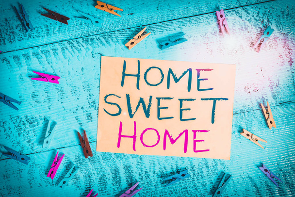 Konceptualny rękopis pokazujący Home Sweet Home. Biznes photo text In house finally Comfortable feeling Relaxed Family time Kolorowy prostokąt w kształcie szpilki papier niebieski tło. - Zdjęcie, obraz
