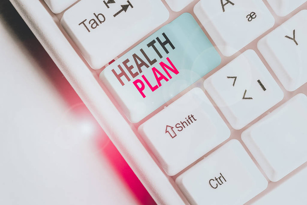 Writing note showing Health Plan. Business photo showcasing entity that provides coverage of designated health services White pc keyboard with note paper above the white background. - Photo, Image