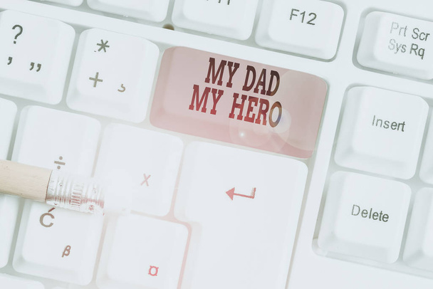 Text schreiben, mein Vater, mein Held. Geschäftskonzept für die Bewunderung für Ihren Vater Liebe Gefühle Emotionen Kompliment weiße PC-Tastatur mit leerem Notizpapier über weißem Hintergrund Schlüssel Kopierraum. - Foto, Bild