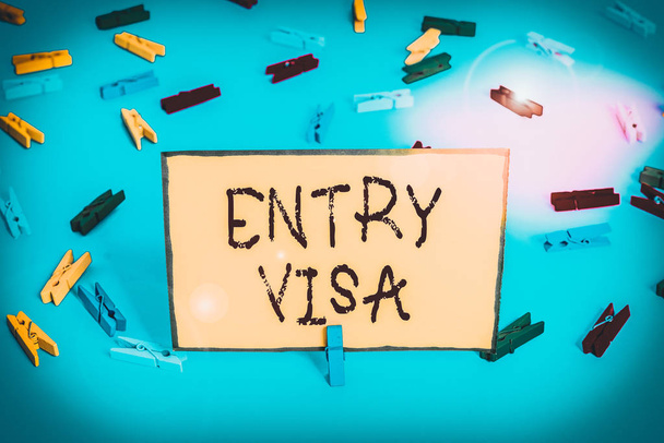 Word writing text Entry Visa. Business concept for permission to enter a country of which you are not a national Colored clothespin papers empty reminder blue floor background office pin. - Photo, Image