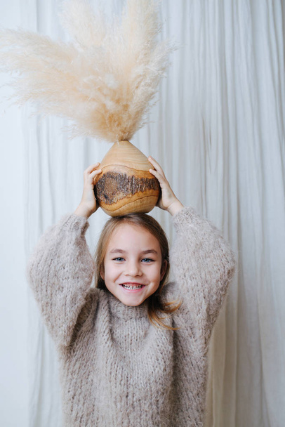 Little girl holding coconut vase with cereal bouquet on top of her head - Fotoğraf, Görsel