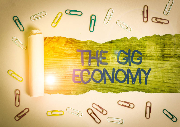 Kézírás szöveg A Gig Economy. Koncepcionális fotó Rövid lejáratú szerződések piaca szabadúszó munka ideiglenes gemkapocs és szakadt karton egy fa klasszikus asztali háttér fölé helyezve - Fotó, kép