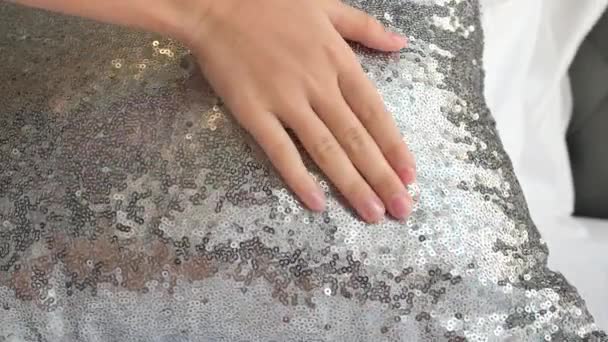 Νεαρό κορίτσι συρόμενο χέρι πάνω από μαξιλάρια glitter. - Πλάνα, βίντεο