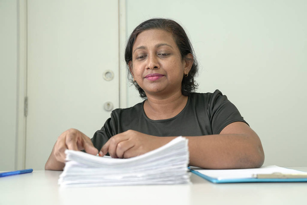 Femme gestionnaire ou cadre supérieur examinant les documents versés au dossier
 - Photo, image