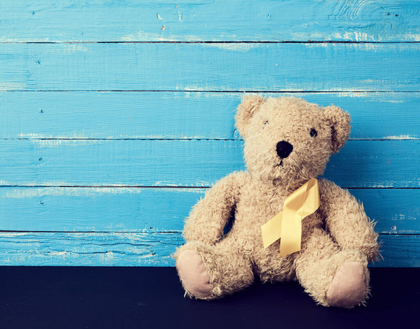 brown teddy bear sits on a blue background - Фото, зображення