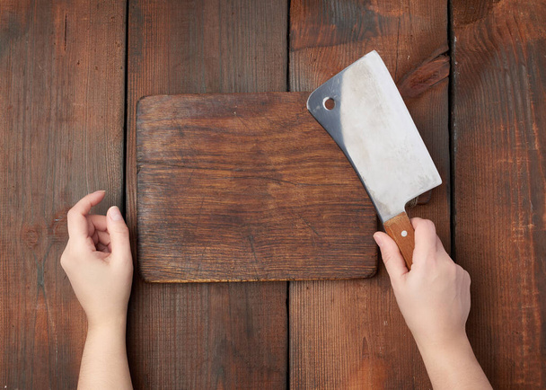 tabla de cortar rectangular de madera vacía muy vieja y las manos sostienen un
 - Foto, imagen