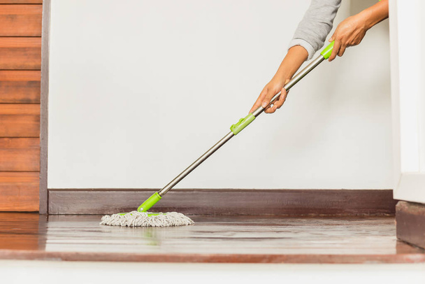 Main de femme tenant une serpillière nettoyant le sol de la maison
. - Photo, image
