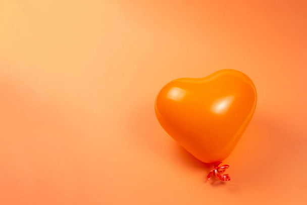 Orange heart ballon on orange background.  - Foto, Imagem