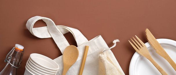 Zero waste concept. Set of reusable produce bag, bamboo cutlery, carton cups and plate, glass bottle. Plastic free sustainable lifestyle. Flat lay, top view. - Foto, Imagem