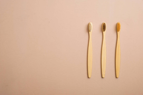 Top view eco natural bamboo toothbrushes on beige background. Zero waste, plastic free concept. - 写真・画像