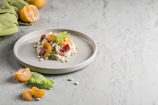 Delicious salad with tangerines, chicken, pine nuts, lettuce and - Foto, afbeelding