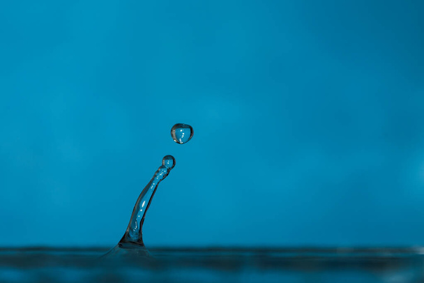 water drops splash forming ripples and waves and abstract water columns - 写真・画像