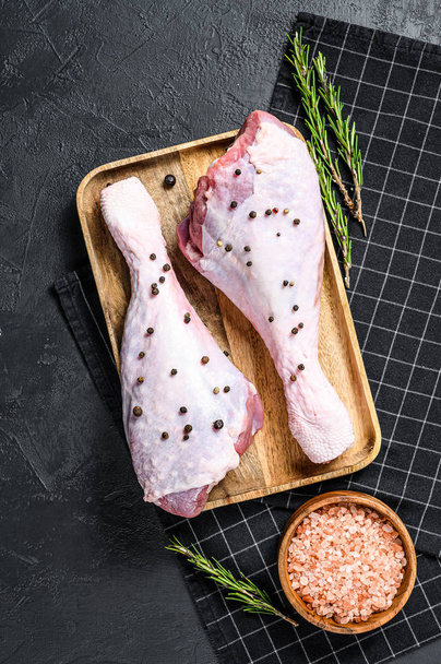 Raw chicken thigh with spices. Black background. Top view - Photo, Image