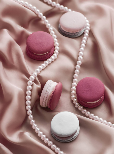 Macaroni dolci e gioielli di perle su sfondo di seta, parisia
 - Foto, immagini
