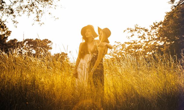 Portrait of two girls having fun in a field - Φωτογραφία, εικόνα