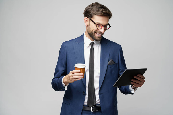 Young Businessman holding digital tablet pc pad and paper cup of coffee - Foto, Bild