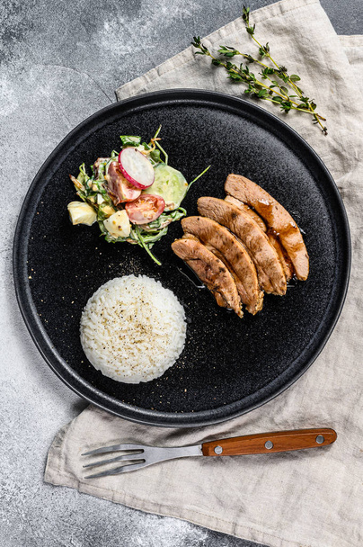 Gegrilde biefstuk met kipfilet, versierd met rijst. Grijze achtergrond. Bovenaanzicht - Foto, afbeelding