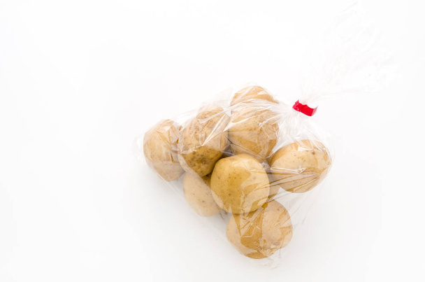 papa fresca en bolsa de plástico sobre fondo blanco
 - Foto, Imagen