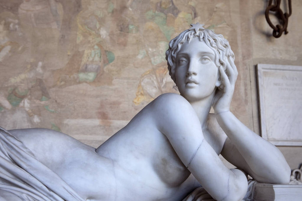 Neoclassical statue. Half-naked young beautiful woman Sculpture. Marble nude laying woman body. Pisa Italy - 写真・画像