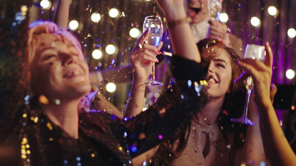 Zbliżenie grupy przyjaciół na przyjęciu urodzinowym tańczących razem uśmiechając się duże otwierają konfetti i ciesząc się imprezową nocą - Materiał filmowy, wideo