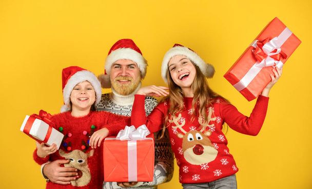 time for presents. happy family celebrate xmas. small girls exchange gifts with father. dad love daughters. bearded santa man with kids. knitted fashion for winter. new year shopping - Φωτογραφία, εικόνα