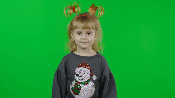 Szczęśliwa piękna dziewczynka w swetrze ze bałwanem. Święta. Klucz chromowy - Zdjęcie, obraz