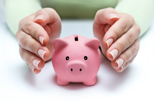 Schützen Sie Ihre Ersparnisse - mit Händen und Sparschwein - Foto, Bild