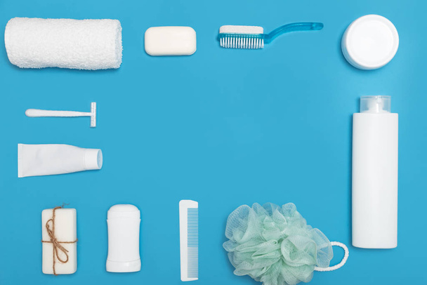 Productos higiénicos para el cuidado del cuerpo y la piel, en envases blancos sobre fondo azul. Acostado. Copiar espacio
 - Foto, imagen